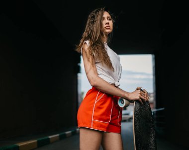 Kırmızı şortlu güzel bir kaykaycı kadın yaban domuzuna biniyor.