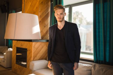 Başarılı genç sarışın adam modern bir çatı katında, nargile.