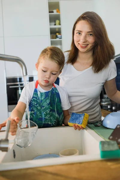 mother and son wash dishes together