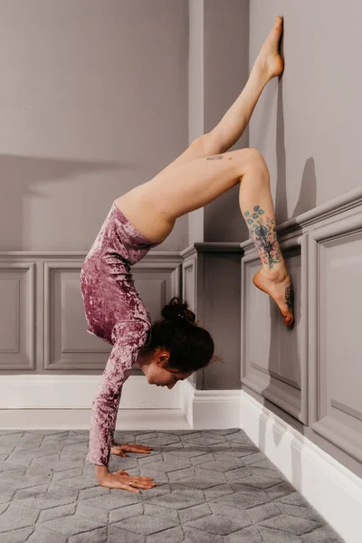 Very flexible young girl doing yoga in the minimalism room — Stock Photo, Image