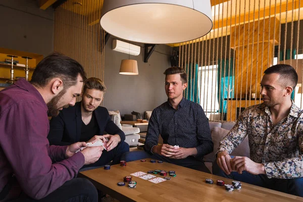 Verschillende mannen spelen poker in een café, met kaarten in hun handen — Stockfoto