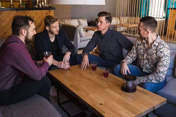 Los hombres beben té en un elegante loft café con un diseño moderno Fotos De Stock