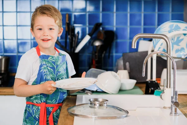 Un niño pequeño que está parado en la cocina Fotos De Stock Sin Royalties Gratis