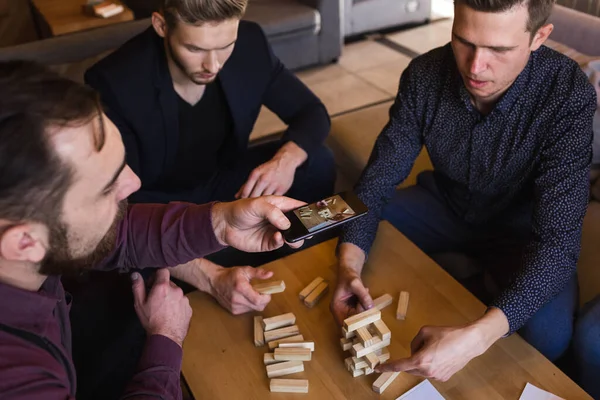 Vrienden spelen een spelletje in een stijlvol café met een modern design — Stockfoto