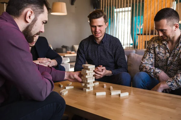 Vrienden spelen een spelletje in een stijlvol café met een modern design — Stockfoto