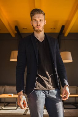 Başarılı genç sarışın adam modern bir çatı katında, nargile.