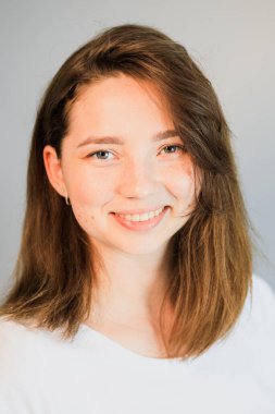 Gülümseyen ve kameraya bakan birinin yakın çekimi.