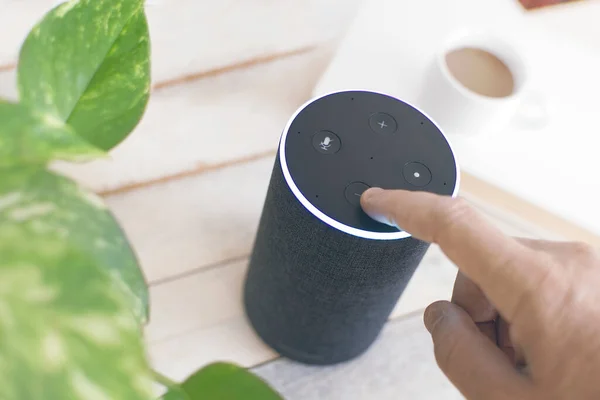 Alexa ev otomasyonlu bir kullanıcının eli, akıllı bir hoparlör cihazı. Düzenleyicinin metni için boş kopyalama alanı.