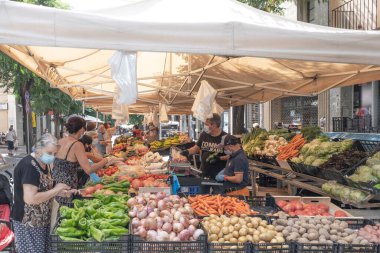 Sokak pazarındaki insanlar yüz maskesi kullanıyor. Caldes de Montbui 'de gıda pazarı