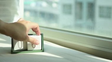 Yeni gün için el değiştiren beyaz ahşap takvim bloğu. Tatlı pembe yatakta, modern pencereden gelen taze sabah ışığı, konsept hayat motivasyonunu başlatır.