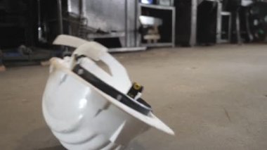 Ekip işini bitirdikten sonra el yapımı güvenlik kaskı gevşetiyor. Coronavirüs 'ün grev çalışanı etkisi iş imalatı üretimini durdurdu.