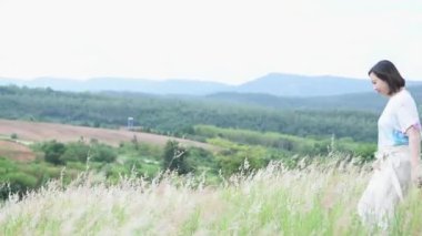 Asyalı güzel bir kadın fotokopi için arka tarafa geçiyor ve doğadaki çimen çiçeklerinde derin dijital detoks soluyor. Sosyal uzaklık için yeni normal karantina kavramını tamamla