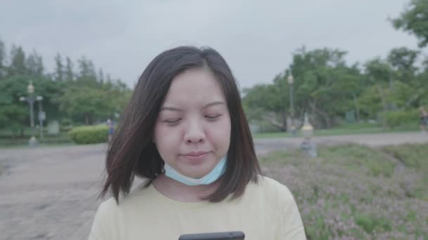 Mujer Asiática Que Usa Mascarilla Después Terminar Llamada Móvil Caminando — Vídeo de stock