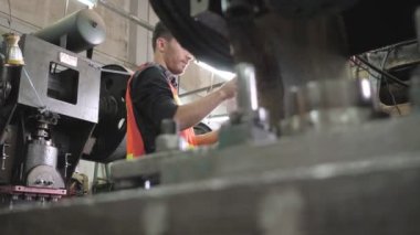 Başlık ve güvenlik gözlüğü takan Kafkas mühendisi çalışmaya hazır. Metal levha fabrikası üretiminde güvenlik üniformasına ara verildi. Dolly kamera yan görünümü