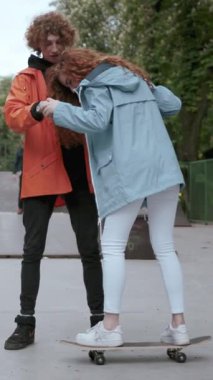 Neşeli bir çift birlikte kaykay, eğlence, destek ve çok sevdikleri canlı bir şehir hayatı.