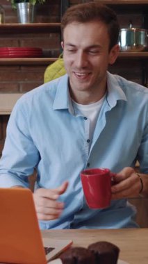 Şık dizüstü bilgisayarına odaklanmış genç bir adam şık, davetkar bir ev ortamında verimlilik sergiliyor.