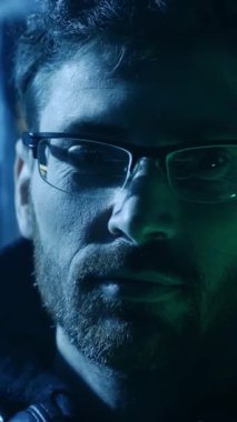 Bu video, gözlüklü, sakallı bir adamın yüz ifadelerini gösteren ve izleyicileri yansıtıcı düşüncelerini keşfetmeye davet eden yakın çekimini içeriyor.