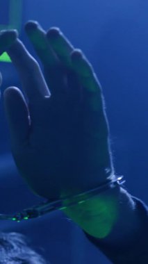 Videoda elleri kelepçeli ellerin, suda yüzen bu ellere geçişi, hapsedilmeyi ve özgürlük arayışını sembolize ediyor.