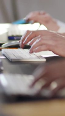 Ellerin klavyede aktif olarak yazarken aynı zamanda bir fareyi manevra yaparken, modern çalışma ayarlarını gösteren yakın çekim görüntüsü