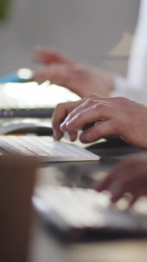 Pürüzsüz, modern, çağdaş ofis ortamında dizüstü bilgisayarlar üzerinde çalışan ellerin detaylı bir yakın çekimi.