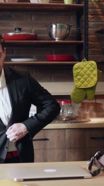 Bu şık mutfak, canlı yeşil bir fırın eldiveni ve büyüleyici kırsal ahşap raflarla vurgulanmış modern bir dekora sahip.