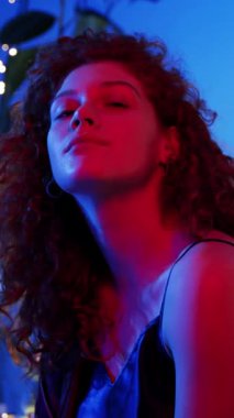 Güzel, kıvırcık saçlı, ışıl ışıl, çarpıcı bir kadının büyüleyici portresi.