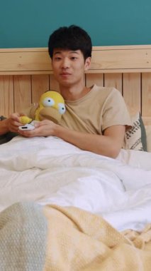 Genç bir adam yatakta rahatlıyor, elinde onun rahatlığını ve masumiyetini sembolize eden tuhaf bir oyuncak tutuyor.