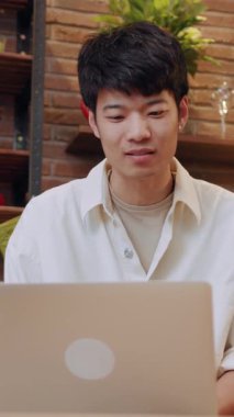 Genç bir adam rahat bir iç mekan ortamının keyfini çıkarırken laptopunda üretken bir şekilde çalışıyor.