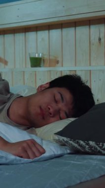 Huzurlu ve huzurlu bir an. Huzurlu ve davetkar bir yatak odasında huzur içinde uyuyan genç bir adam.