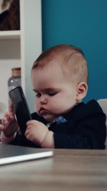 Sevimli bir bebek dizüstü bilgisayara odaklanmış, merak, masumiyet ve modern ebeveynlik becerilerinin bir karışımını sergiliyor.