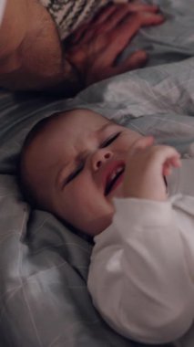 Sevimli küçük bir bebek rahat bir şekilde yumuşak ve sıcak bir battaniyenin üzerinde uzanıyor ve gerçekten huzurlu bir anın tadını çıkarıyor.