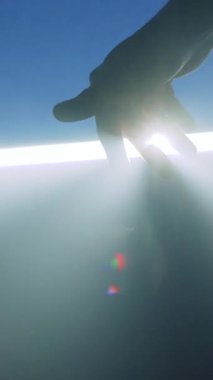 Büyüleyici bir görüntü uzanan bir eli gösterir, parlak ışık ve gelişmiş gölgelerle aydınlatılır, merak uyandırır.