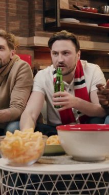 İki yakın arkadaş birlikte harika bir oyun gecesinin tadını çıkarırken çeşitli lezzetli atıştırmalıklar ve içecekler yiyorlar.