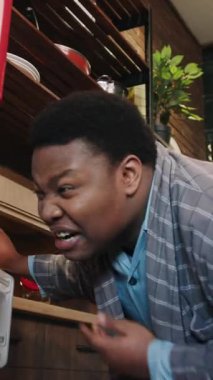 Şık bir bornoz giymiş bir adam, parlak bir mutfakta, sakin ve huzurlu bir sabah atmosferi sergiliyor.