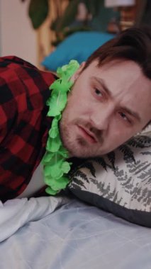 Bir şampanyayı şakasına elinde tutan bir kişinin rahatça yatakta uzandığı rahat bir sahne.