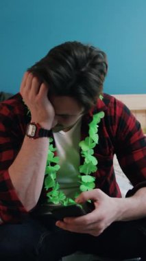 Canlı yeşil bir zambağı olan bir adam akıllı telefonuyla düşünceli bir şekilde oturur ve harika bir rahatlama ortamı yaratır.