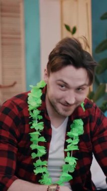 Şenlikli şapkalı ve yeşil yapraklı neşeli bir adam parti havasının özünü somutlaştıran canlı bir kutlamanın tadını çıkarıyor.