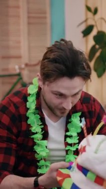 Bir insan, etrafında canlı ve renkli parti süslemeleriyle dolu neşeli bir toplantının keyfini çıkarıyor.