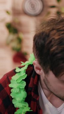 Tarz sahibi fanila gömlekli genç bir adam çevresine odaklanmış ve canlı yeşilliğe dalmış.