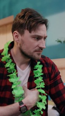 Yeşil yapraklı ve ekose gömlekli genç bir adam sohbete daldı, canlı bir atmosfer yarattı.