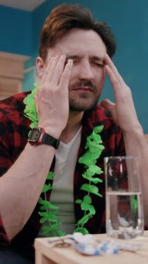 Yeşil yapraklı düşünceli bir adam keyifli bir partide içki içerken derin düşüncelere dalıyor.