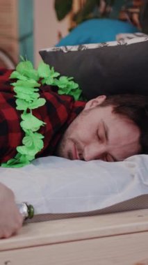 Bir adam rahat ve rahat bir atmosfer sunan şenlikli yeşil bir çiçek kolyesi giyerken huzur içinde uyuyor.