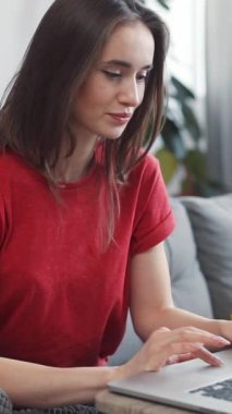 Kapalı bir ortamda uzaktan kumandalı bir işle meşgul olan genç bir kadın konsantre olurken ışıl ışıl gülümsüyor.