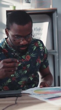 Bir adam yenilikçi fikirler çizer, yaratıcılığı ve konsantrasyonu modern bir çalışma alanında gösterir ve üretkenliğe ilham verir.