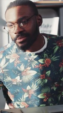 Bir adam dikkatle odaklanmış, dizüstü bilgisayarı üzerinde çalışıyor, ev hayatı ve tarzından modern bir çalışma sergiliyor.