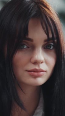 Genç bir kadın dikkatlice aşağıya bakar, uzun, koyu saçları sakin ve huzurlu ifadesini tamamlar.