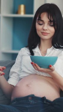 Mutlu bir anne atıştırmanın tadını çıkarır ve telefonunu karıştırır. Bu huzurlu anda kendini mutlu ve neşeli hisseder.