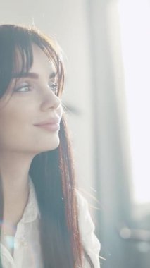 Onu çevreleyen doğal ışıkla hafifçe aydınlatılmış bir kadının yumuşak, ruhani ve rüya gibi bir görüntüsü.