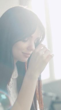 Düşünceli genç bir kadın, etrafını saran yumuşak ve parlayan ışıkla dolu huzurlu bir andan zevk alır.