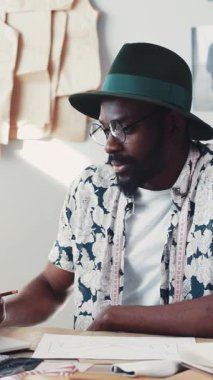 Yetenekli bir tasarımcı, malzeme ve aletlerle dolu canlı bir stüdyoda eşsiz moda modellerine odaklanmış.